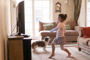 pre-schooler dancing in front of television